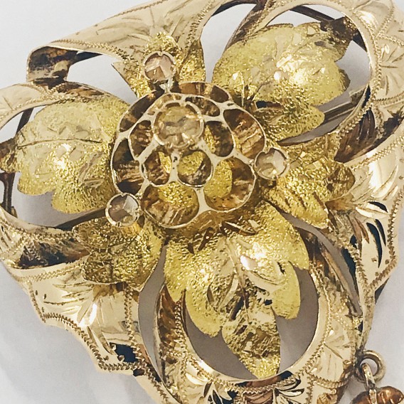 Broche triangular de oro con diamantes.